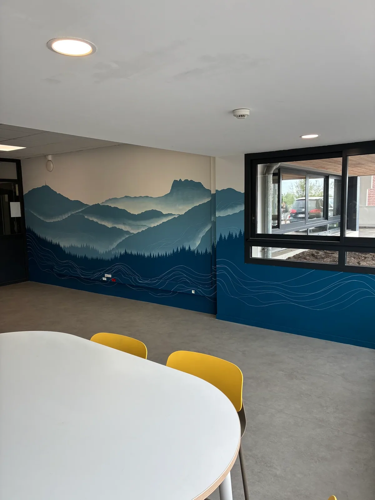 Fresque murale personnalisée de montagnes bleues et de vagues dans une salle de pause professionnelle
